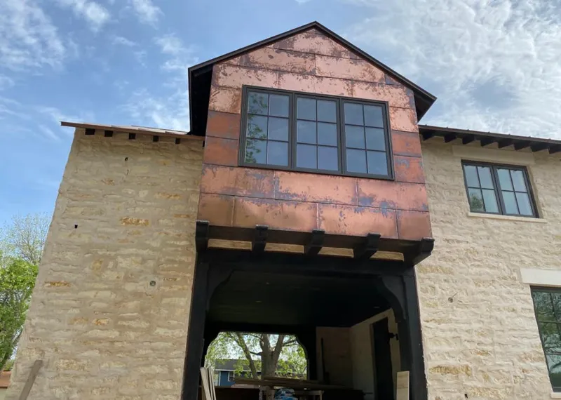 Copper metal panel facade on a stone building for Roof Repair in Independence